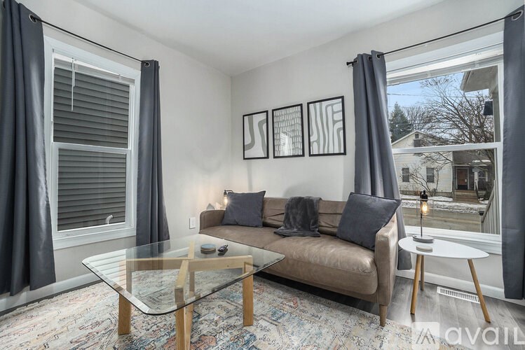 A living room with a couch, coffee table, and pictures on the wall.