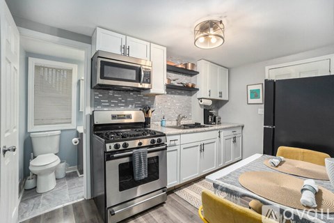 A modern kitchen with a stove top oven and microwave above it.