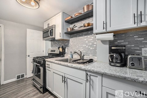 A kitchen with a stove, oven, microwave, and toaster.