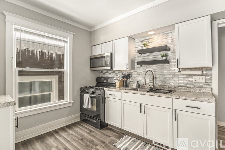 A kitchen with white cabinets and a black oven.