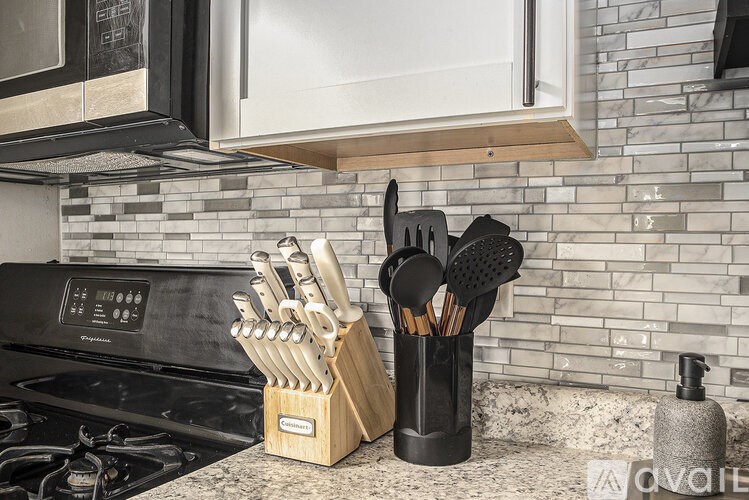 A kitchen counter with a knife block and a pot holder.