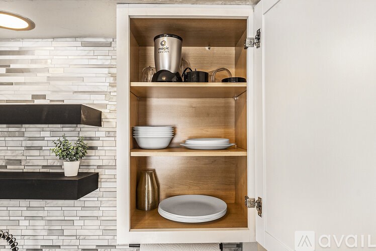 A kitchen cabinet with a pot and a plate inside.