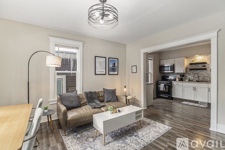 A living room with a brown couch, a white coffee table, and a lamp.