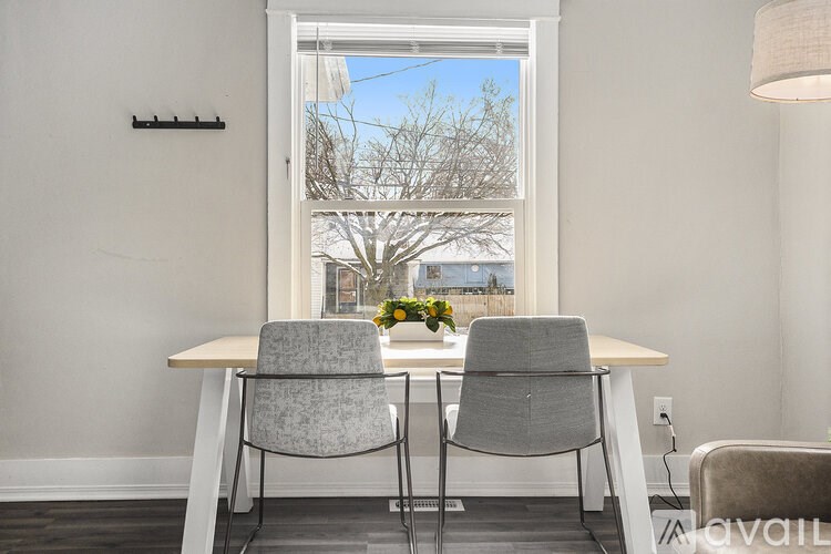 A dining room with a table and two chairs.