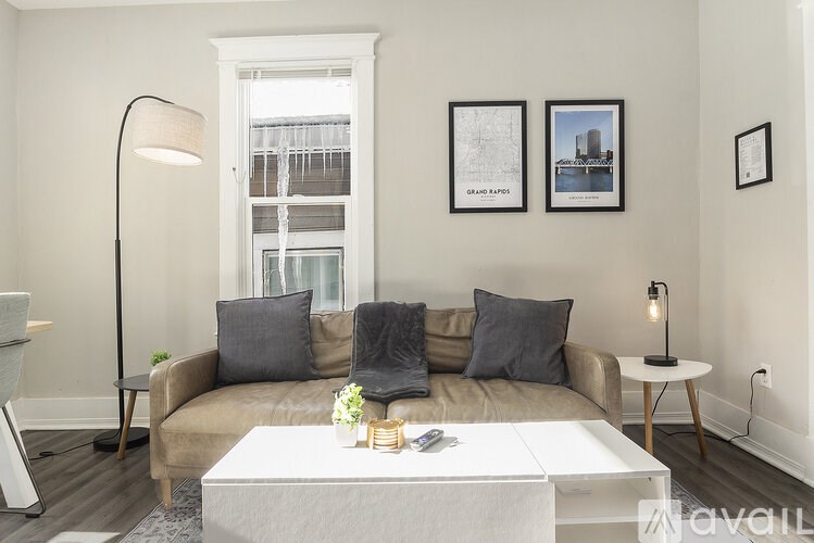 A living room with a couch, a coffee table, and pictures on the wall.