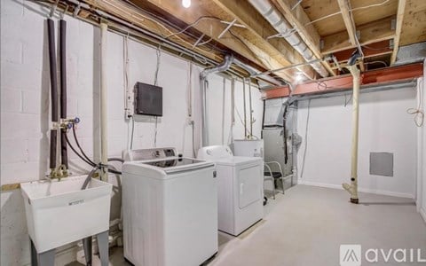 A room with a washer and dryer, and a wall-mounted heater.