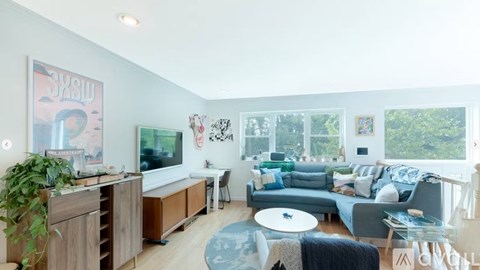 A living room with a grey couch and a wooden cabinet.