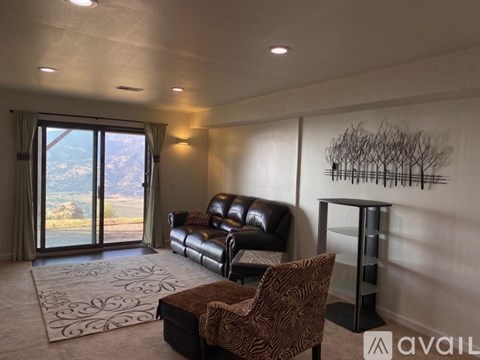 A living room with a leather couch and a chair.