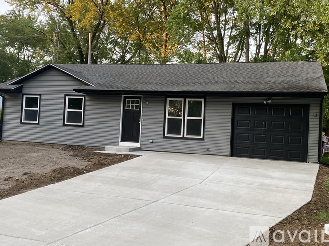 A grey house with a black door and windows.