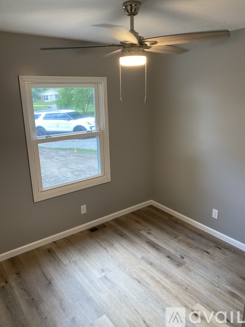 A room with a window and a ceiling fan.
