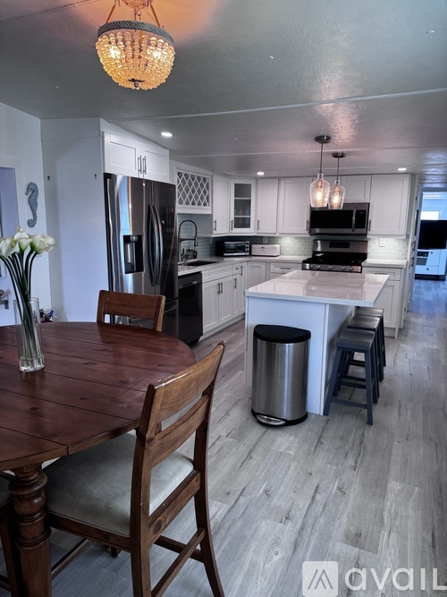 A kitchen with a wooden table and chairs.