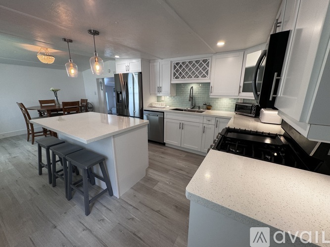 A kitchen with a white countertop and black appliances.