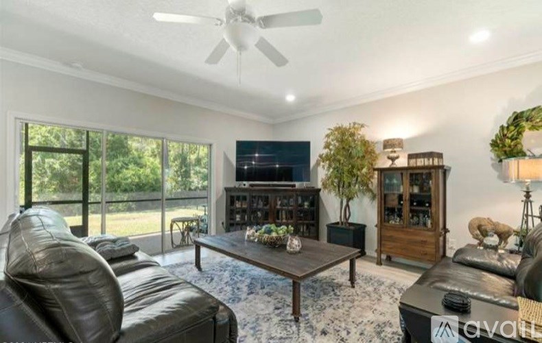 A living room with a black leather couch and a wooden coffee table.