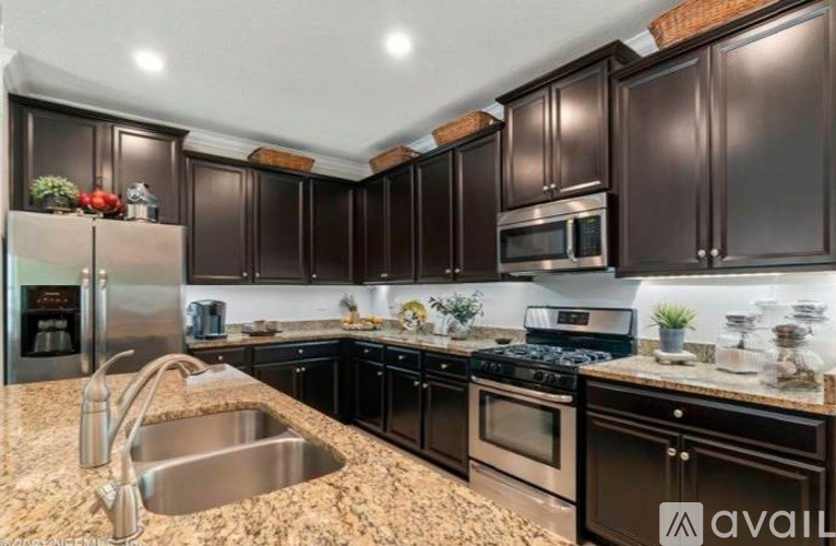 A kitchen with brown cabinets and a granite countertop.