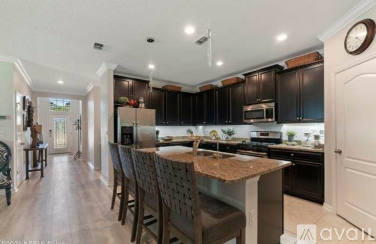 A kitchen with dark brown cabinets and a wooden island.