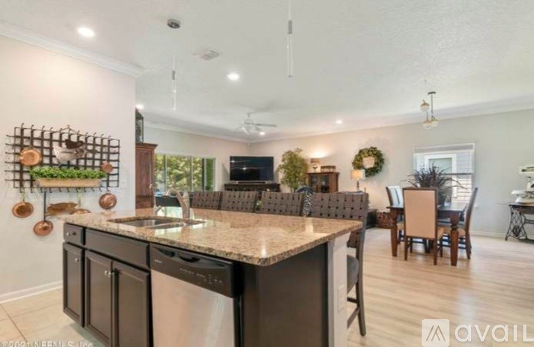 A modern kitchen with a granite countertop and stainless steel appliances.