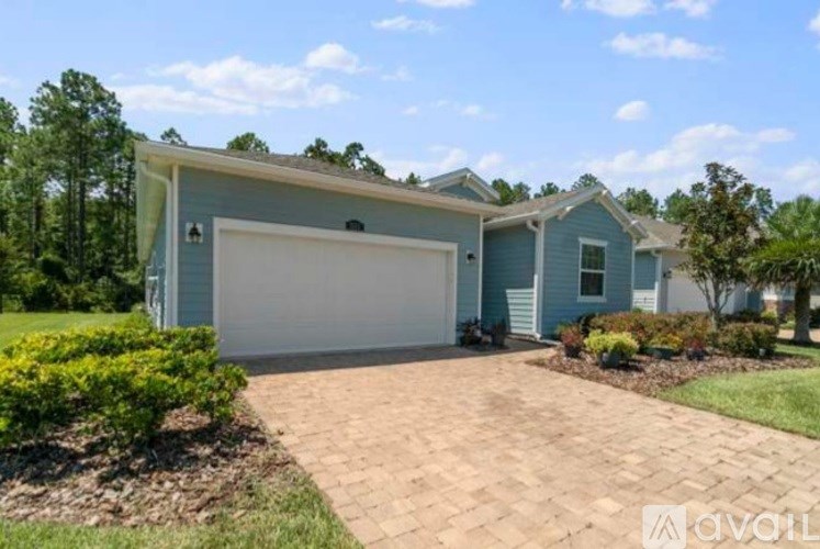 A blue house with a white garage door and a driveway.