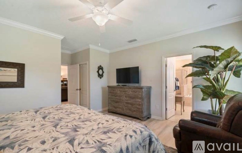 A bedroom with a large bed and a flat screen TV.