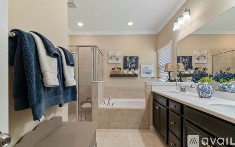 A bathroom with a tub, sink, and towel rack.