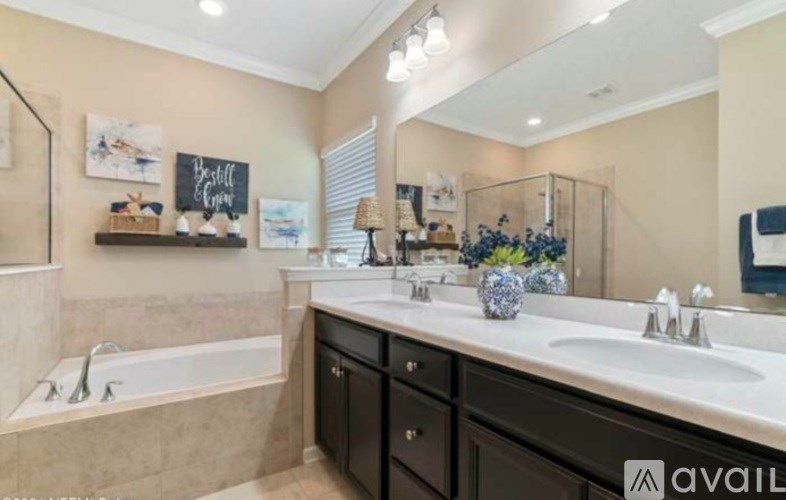 A bathroom with a tub, sink, and mirror.