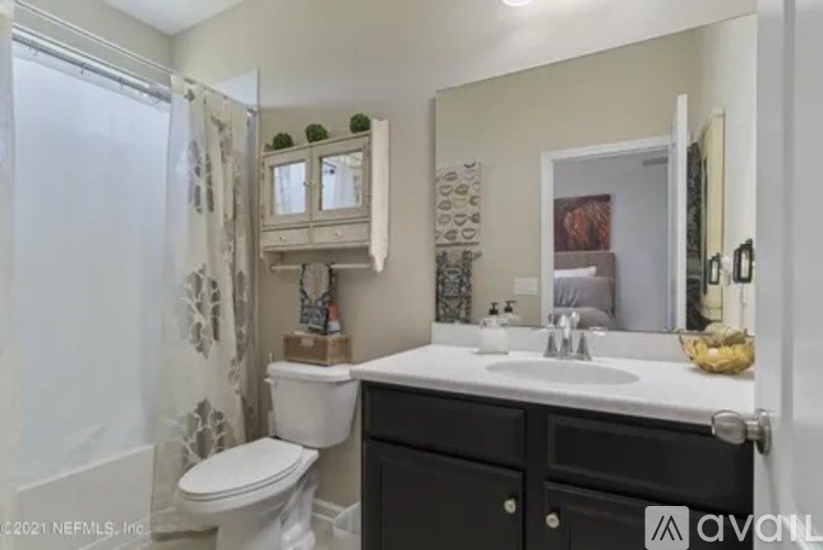 A bathroom with a white toilet, a sink, and a mirror.