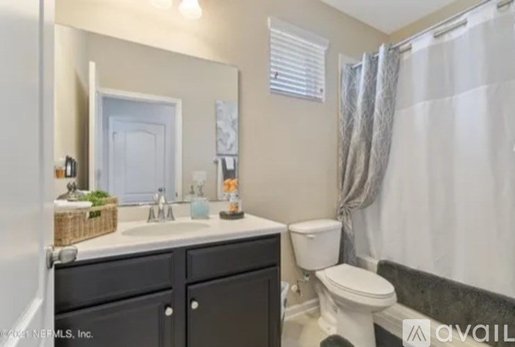 A bathroom with a white toilet, sink, and a mirror.