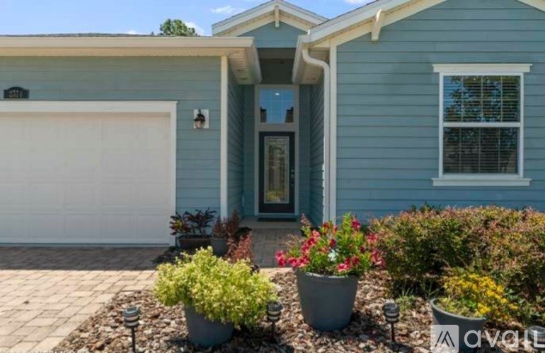 A blue house with a white garage door and a green door.