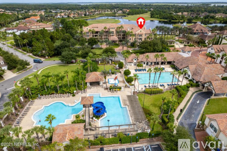 A bird's eye view of a resort with a pool and a red marker on a building.