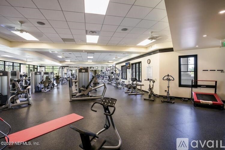 A gym with a variety of exercise equipment including treadmills, weights, and exercise bikes.