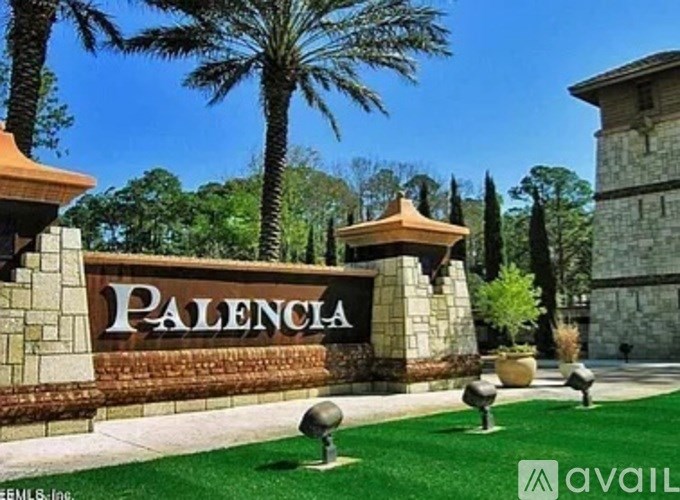 The entrance to Palencia with a sign and a wall.