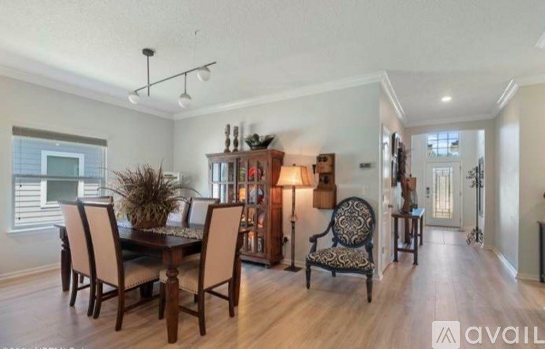A dining room with a wooden table and chairs.