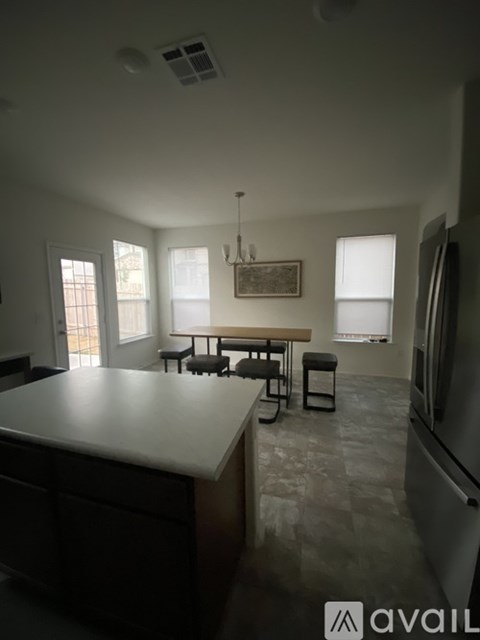 A kitchen with a table and chairs in the middle of the room.