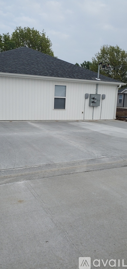 A white building with a grey roof and a grey door.