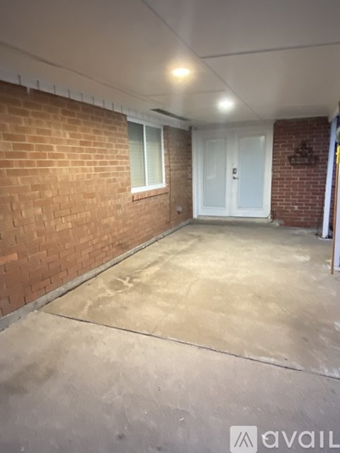 A room with a brick wall and a white door.