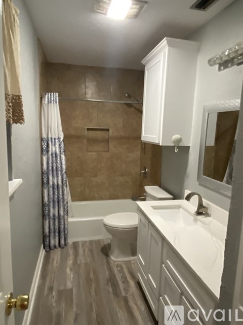 A bathroom with a toilet, sink, and shower.