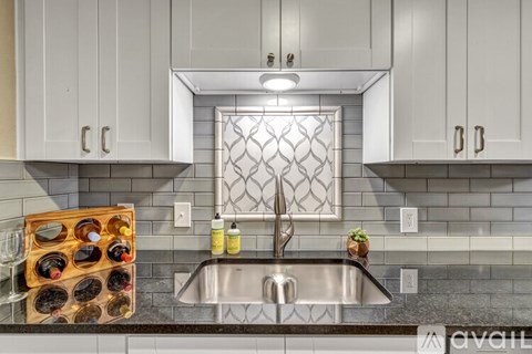 A kitchen with a sink and a wine rack.
