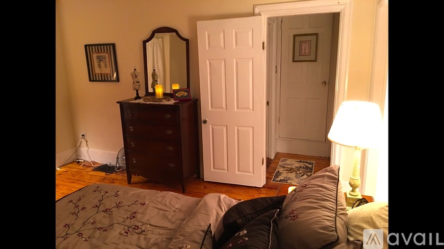 A bedroom with a bed, dresser, and mirror.