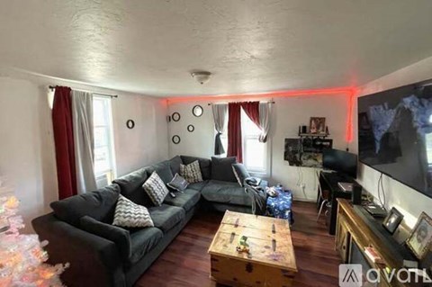A living room with a grey couch and a wooden coffee table.