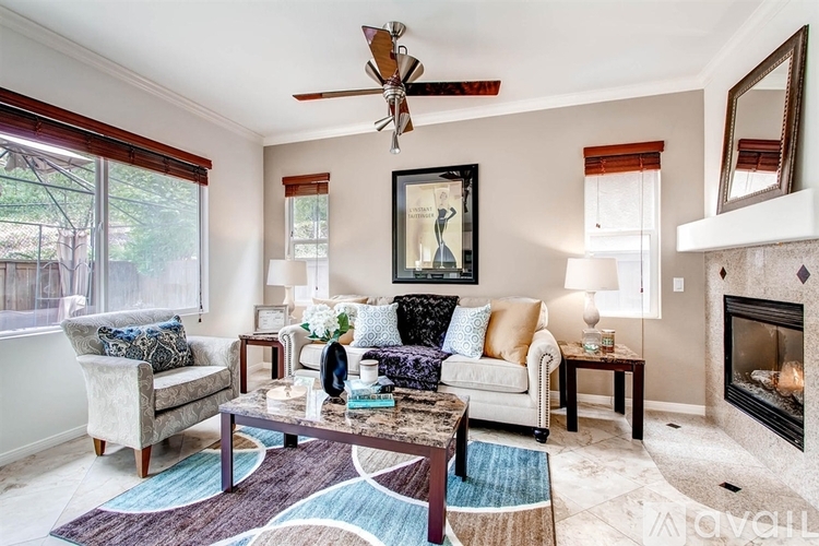 A living room with a fireplace and a painting on the wall.