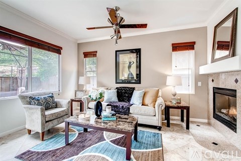 A living room with a fireplace and a painting on the wall.