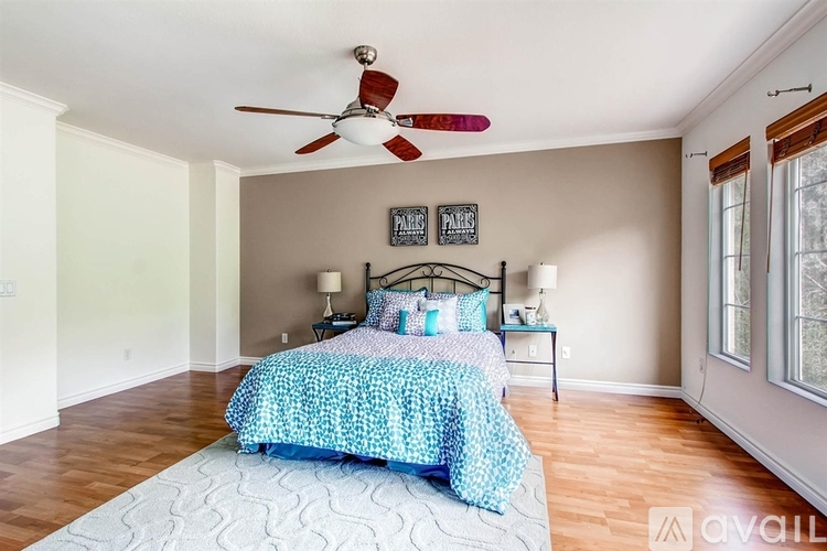 A bedroom with a bed and a ceiling fan.
