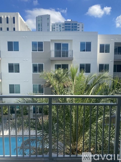 A white apartment building with a pool in front.