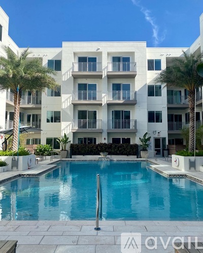 A large white building with a pool in front.