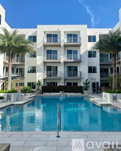 A large white building with a pool in front.
