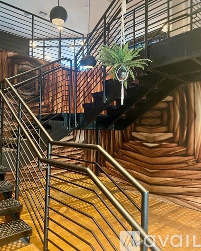 A staircase with a metal railing and a plant hanging from it.