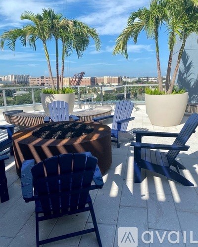 A patio with chairs and a table with a view of the city.