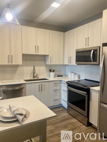 A kitchen with white cabinets and a wooden table.