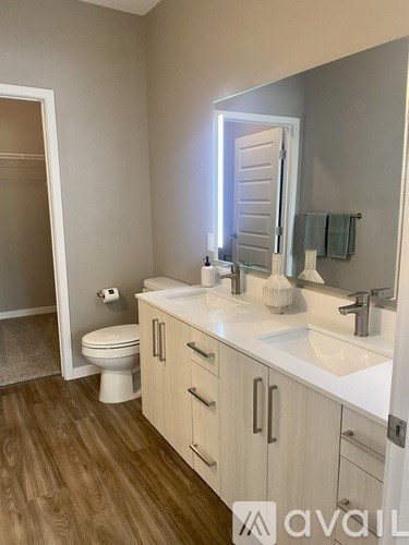 A bathroom with a toilet, sink, and mirror.