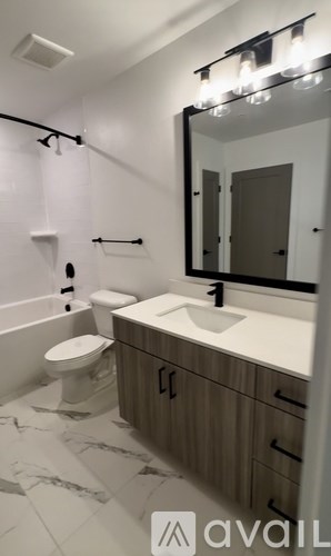 A bathroom with a toilet, sink, and mirror.