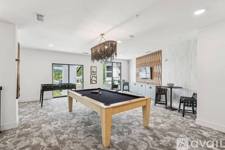 A room with a pool table and a chandelier.